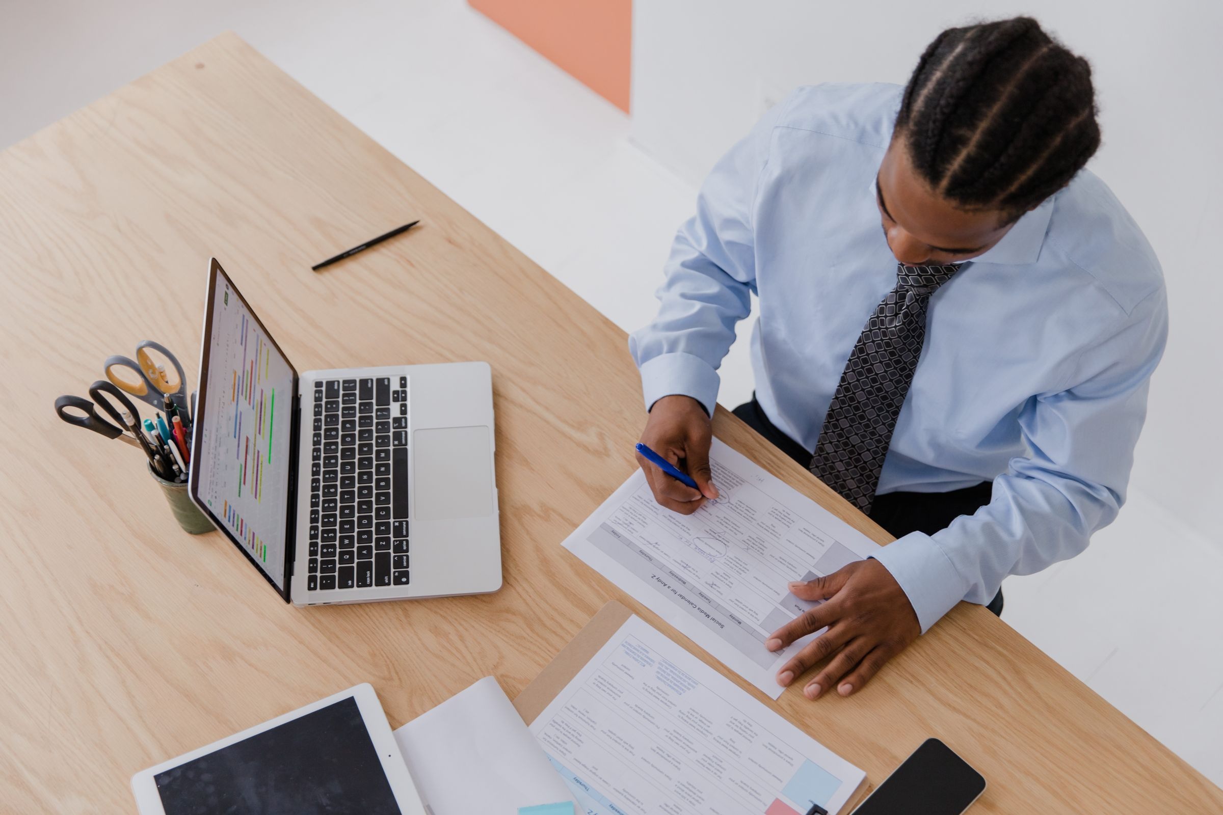 Professional reviewing and signing paperwork at a desk