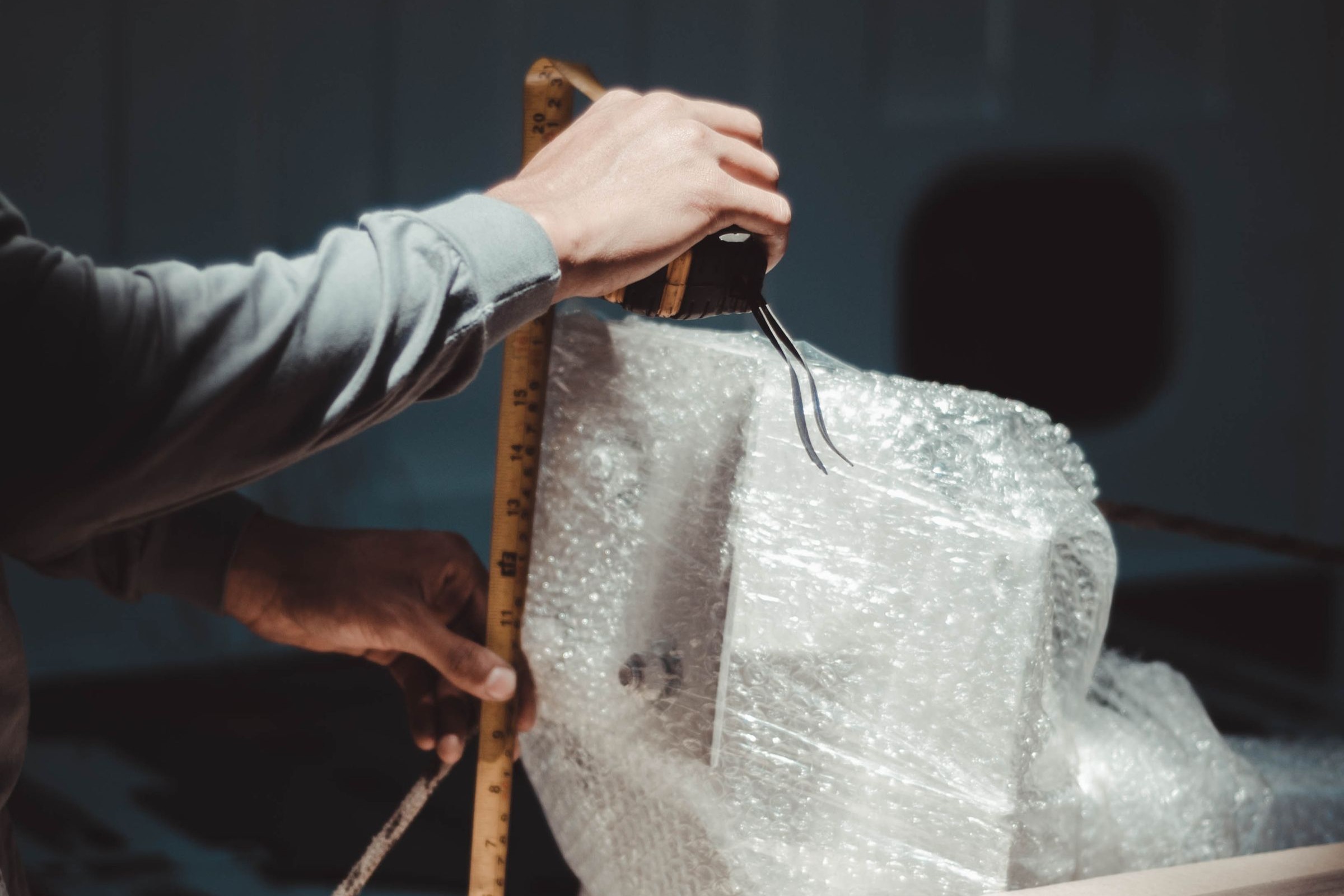 Hands measuring a bubble wrapped package