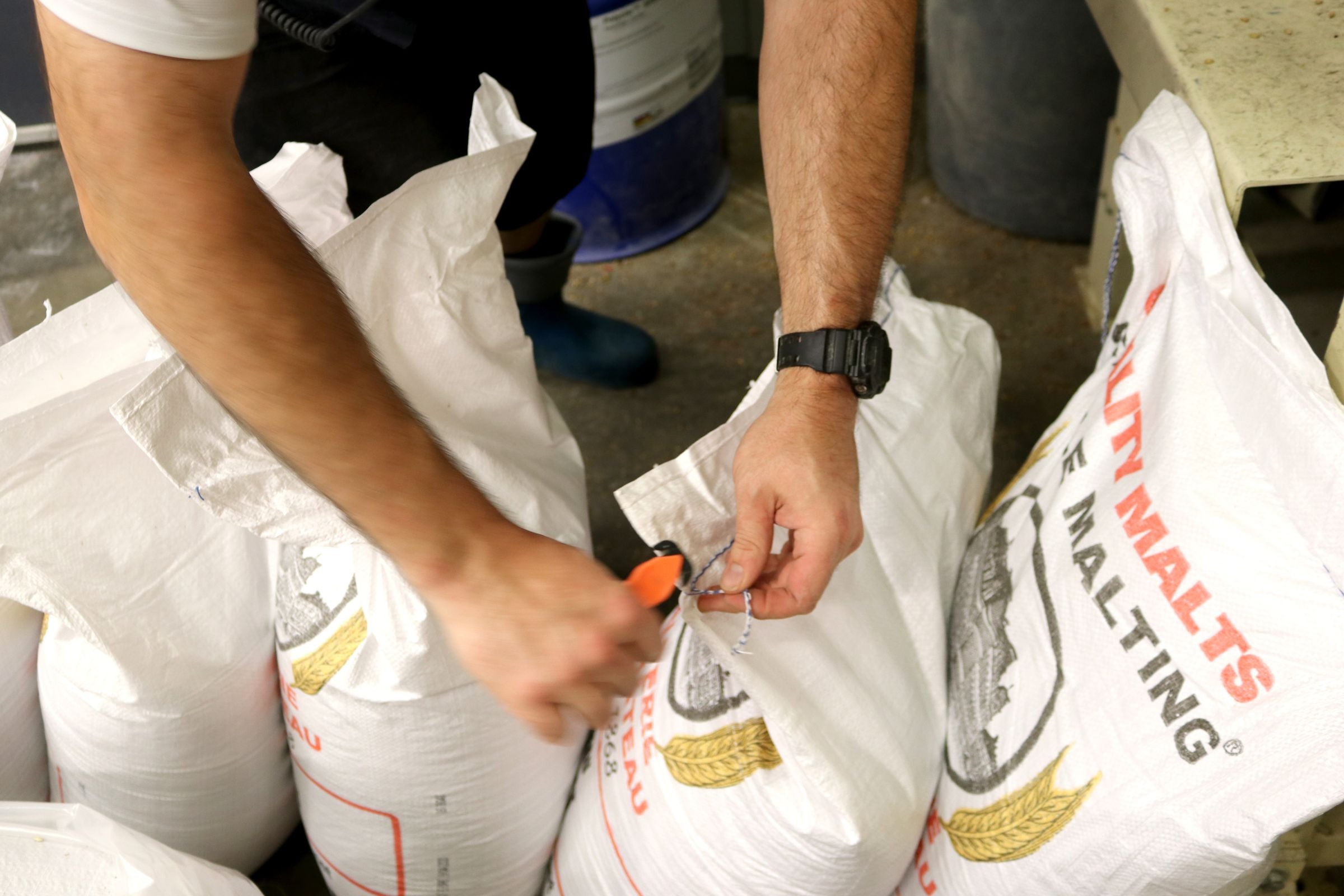 Worker sealing sacks of packaged commodities