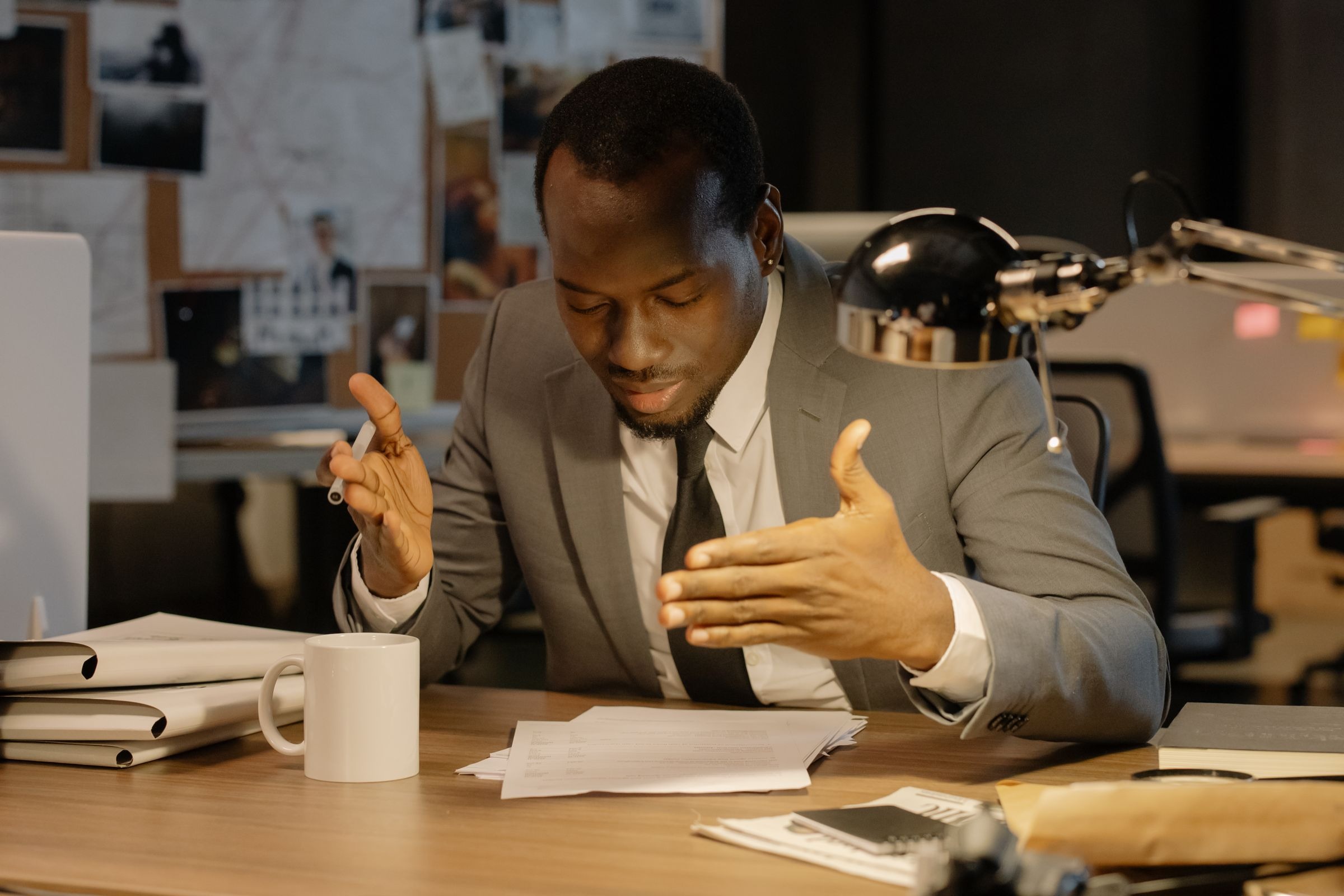 Black male professional reviewing paperwork at an office desk