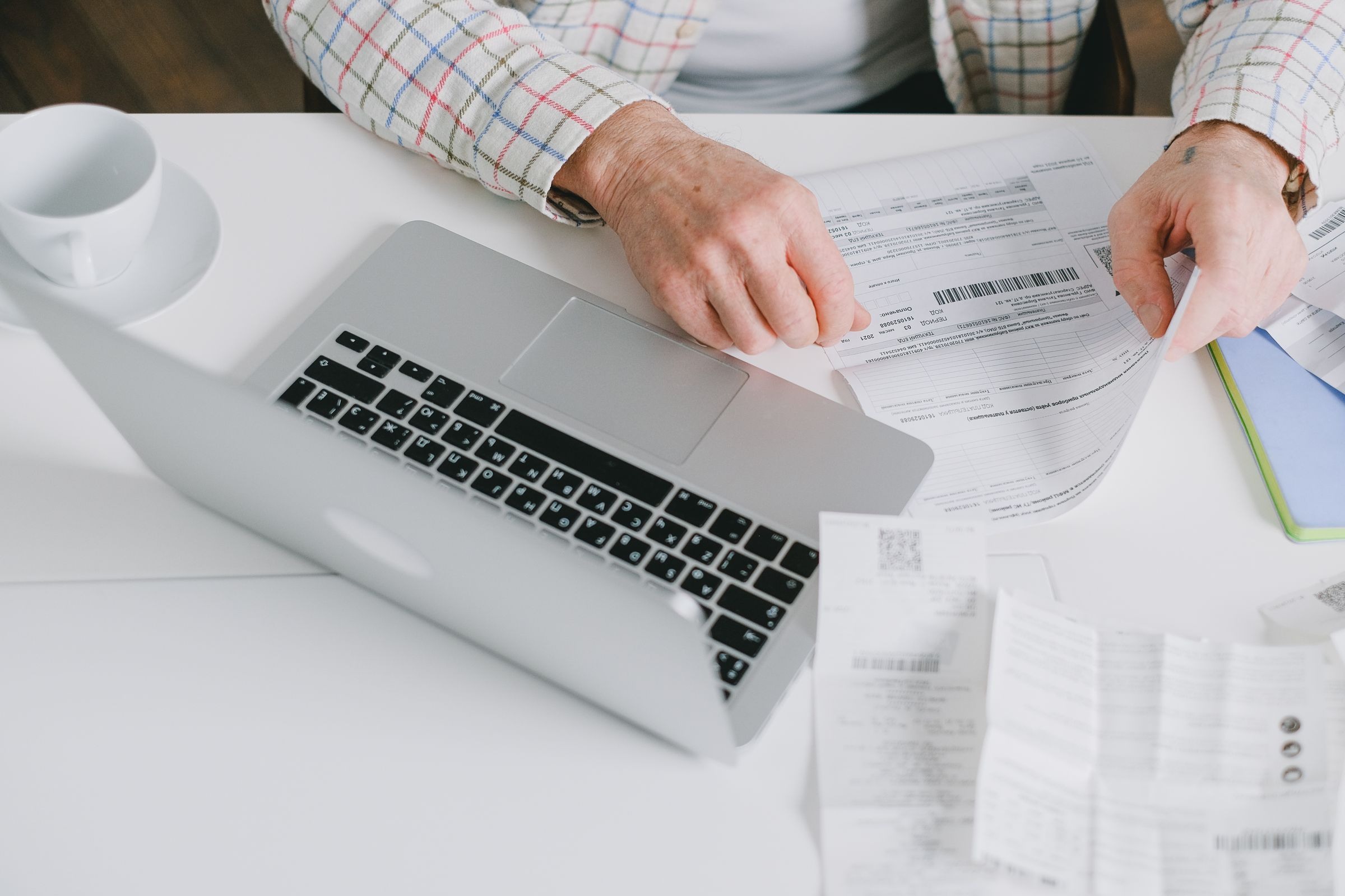 Organizing documents beside a laptop