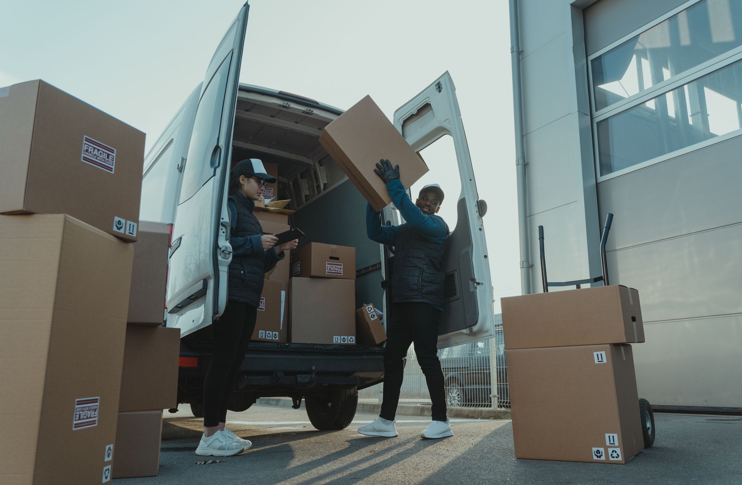Workers handing over and loading boxes at vehicle