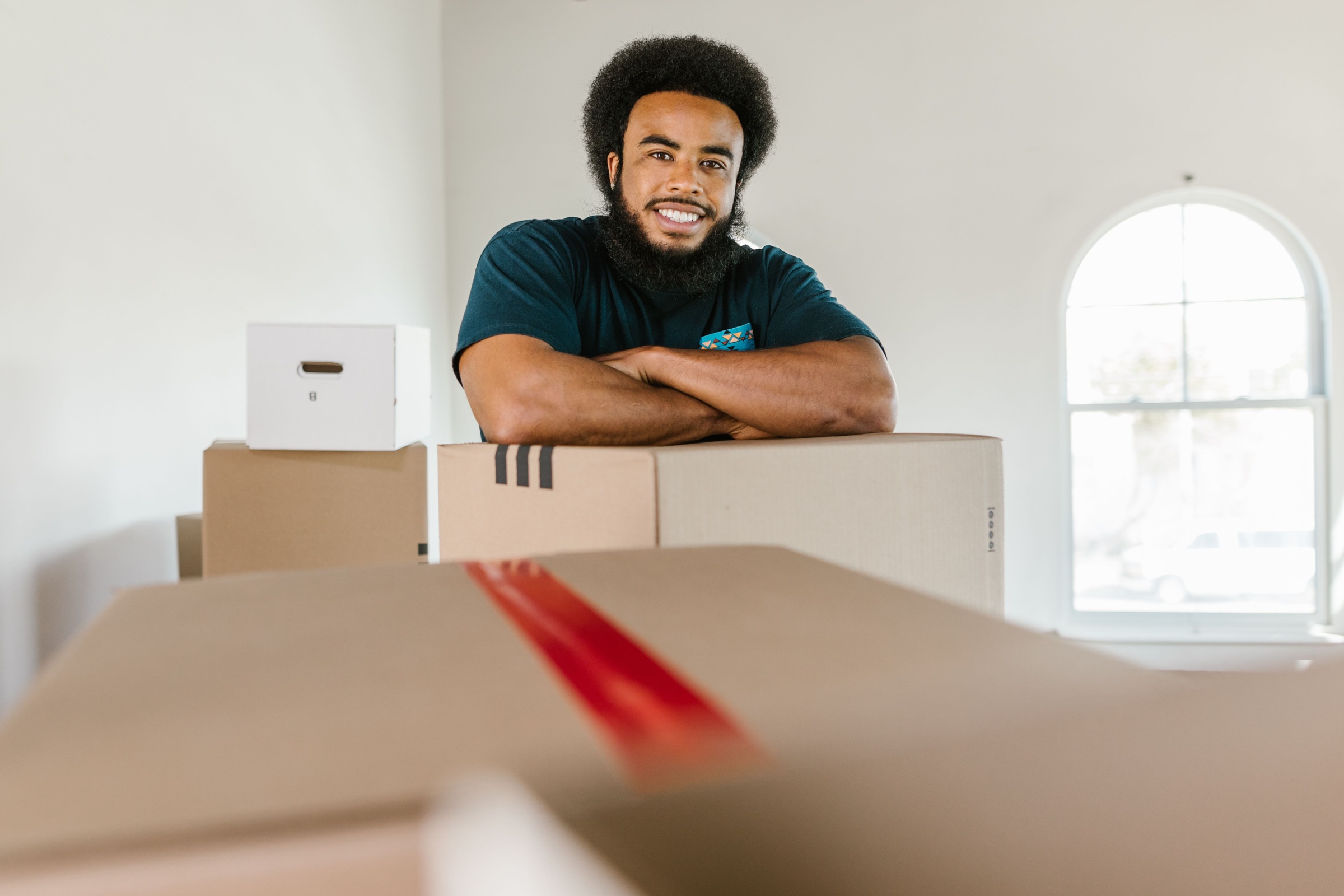 Smiling man beside packed shipping cartons