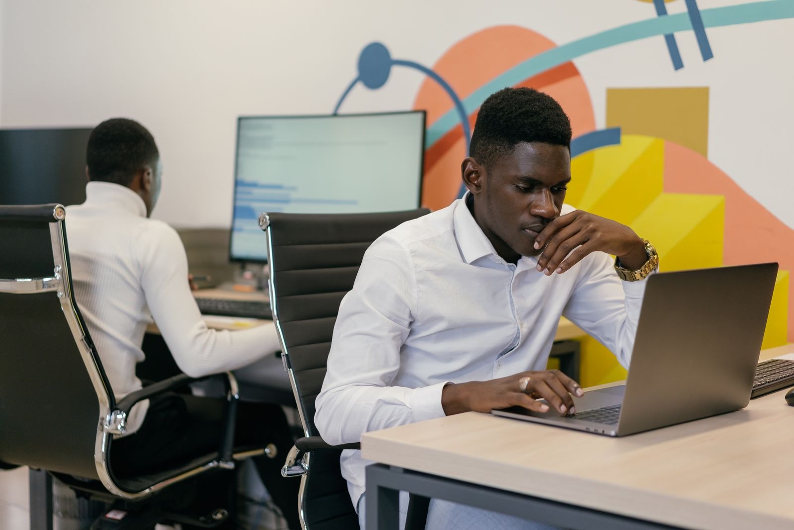 Two Black men working at office desks