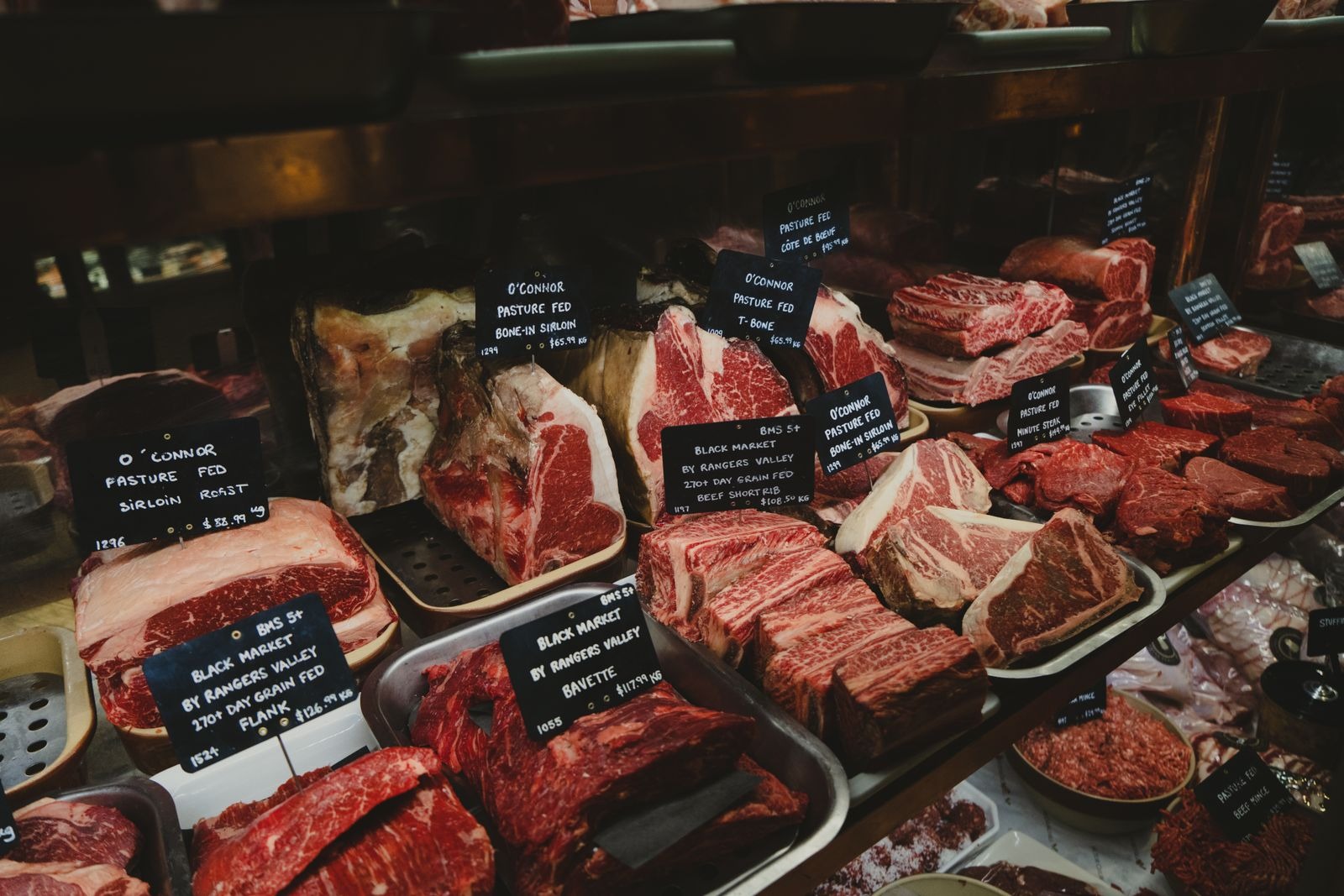 Raw meat cuts displayed in chilled butcher counter